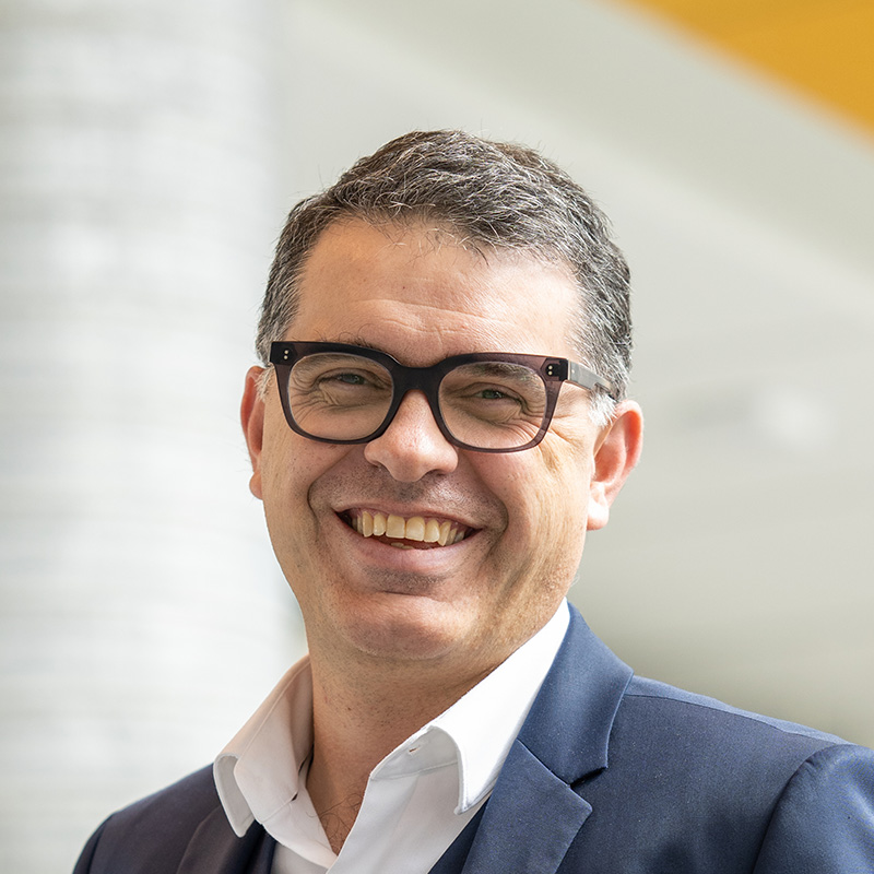 Portrait de Pierre-Majorique Léger, souriant, en veston, sur le campus de HEC Montréal